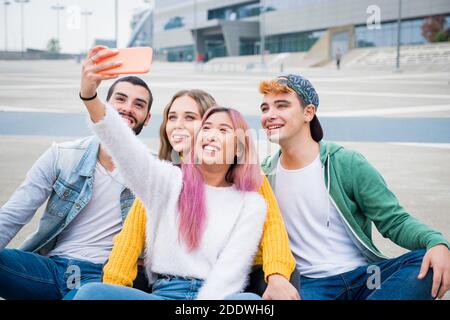 Gruppe von Teneegers lachen und jocking zusammen, während sie ein Videocall mit theyrs Freunde - Gruppe von Freunden im Urlaub Ein Selfie für Remembe machen Stockfoto