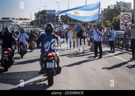 Buenos Aires, Argentinien. November 2020. Fans winken die Flagge Argentiniens, während der Leichenwagen, der die Überreste von Diego Maradona trägt, sie auf dem Weg zum Friedhof passiert. Maradona starb am Vortag im Alter von 60 Jahren. Kredit: Fernando Gens/dpa/Alamy Live Nachrichten Stockfoto