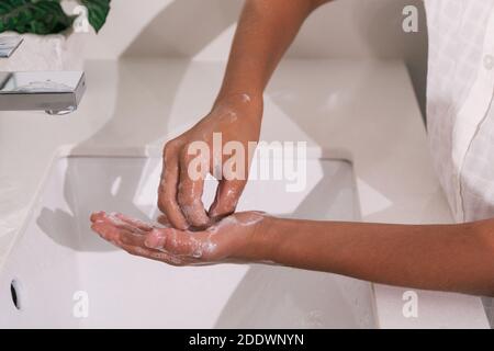 Stock Foto von nicht erkannten Person mit Seife und Wasser, um ihre Hände im Badezimmer zu reinigen. Stockfoto