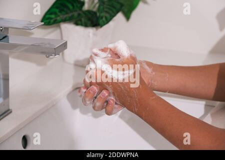 Stock Foto von nicht erkannten Person mit Seife und Wasser, um ihre Hände im Badezimmer zu reinigen. Stockfoto