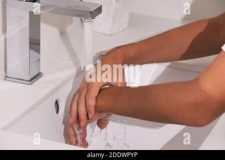 Stock Foto von nicht erkannten Person mit Seife und Wasser, um ihre Hände im Badezimmer zu reinigen. Stockfoto