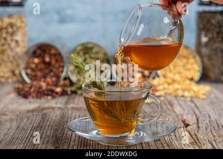 Erfrischender Salbei Tee und Honig, auf rustikalem Holzhintergrund. Ausgewählter Fokus. Minzblätter, Honig mit Löffel und Tasse heißen Tee. Konzept des Herbalismus an Stockfoto