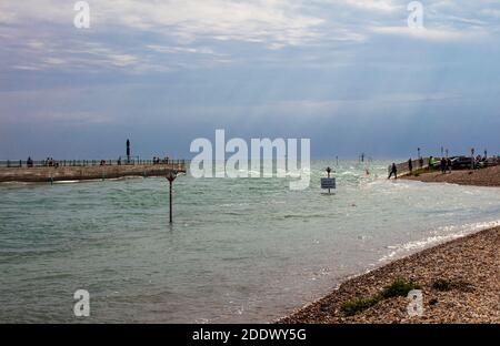 Das Rennen am Eingang zum Fluss Arun, Sommer, Littlehampton, West Sussex, Großbritannien; strahlender Sonnenschein in einem bewölkten Himmel mit Streifen von donnerndem Licht Stockfoto