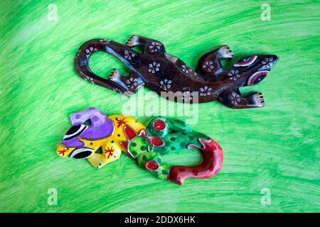 Farbige hölzerne Geckos Puppen' auf abstraktem Aquarell Hintergrund. Stockfoto