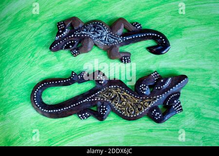 Farbige hölzerne Geckos Puppen' auf abstraktem Aquarell Hintergrund. Stockfoto