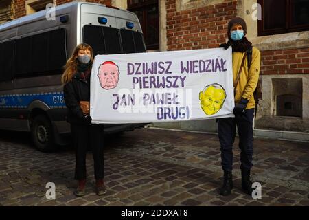 Demonstranten mit Gesichtsmasken halten ein Banner, das sagt, Dziwisz wusste zuerst, Johannes Paul zweite während der Demonstration.Aktivisten protestierten auf Kanoniczna Straße in Krakau. Der Protest war eine Nachwirkung einer kürzlich veröffentlichten Reportage ‘Dauf Stanislao. Das zweite Gesicht von Kardinal Dziwisz', das darauf hinwies, dass Kardinal Dziwisz, langjähriger Helfer von Papst Johannes Paul II., dafür verantwortlich sein könnte, Fälle von Pädophilie unter katholischen Priestern zu vertuschen. Die Menschen versammelten sich auf der Straße und forderten Erklärungen von der Kirche und drückten ihre Unterstützung für die Opfer der Pädophilie aus. Stockfoto