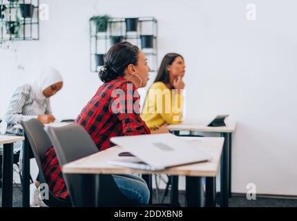 Mehrere ethnische Millennials-Mitarbeiter versammelten sich, um aktuelle Unternehmensthemen zu hören Stockfoto