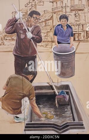 Ein Wandgemälde in der Ong Ang Walking Street bei Klong Ong und in der Chinatown / Phahurat Gegend von Bangkok, Thailand, zeigt städtische Arbeiter, die einen Abfluss reinigen Stockfoto
