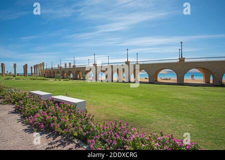 Blick über einen wunderschönen Landschaftsgarten in tropischem Resort mit Große Brücke und Torbögen am Strand Stockfoto