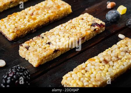 Müsliriegel mit Rosinen und Beeren, auf Holztisch Stockfoto