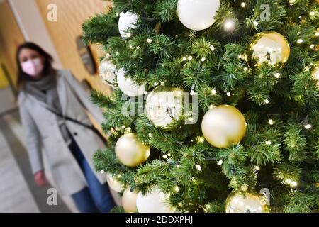 Thema Bild Gefangene in der Coronavirus-Pandemie am 26. November 2020. Eine junge Frau mit Gesichtsmaske, Maske geht an einem Weihaftertsbaum in einem Einkaufszentrum vorbei. Pandemie, Sperrung, Abschaltung, Inzidenzwert. MODELL FREIGEGEBEN! Weltweite Nutzung Stockfoto