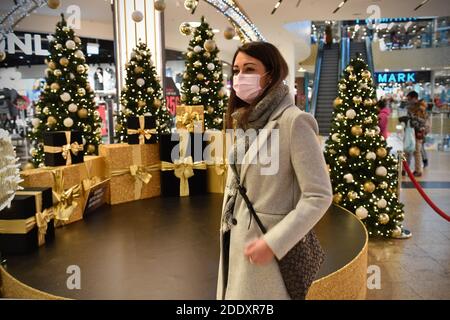 Thema Bild Gefangene in der Coronavirus-Pandemie am 26. November 2020. Eine junge Frau mit Gesichtsmaske, Maske in einer Mall, Einkaufszentrum, sie schaut auf die Weihaftertsverehrung, Weihaftertsbaum, Pandemie, Sperrung, Abschaltung, Inzidenzwert. MODELL FREIGEGEBEN! Weltweite Nutzung Stockfoto