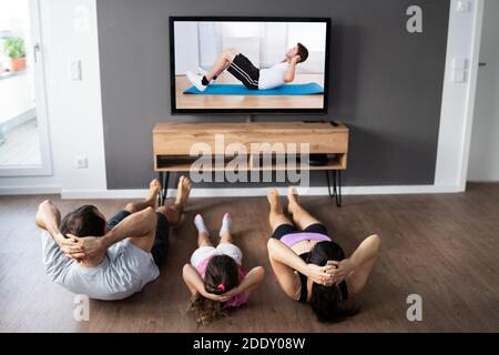 Familie tun Fitness-Übung beim Fernsehen Stockfoto