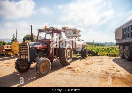 Traktor Landwirtschaftliche Fahrzeug mit einem angeschlossenen Wasserbehälter Tank in Ländliche Landschaft Stockfoto
