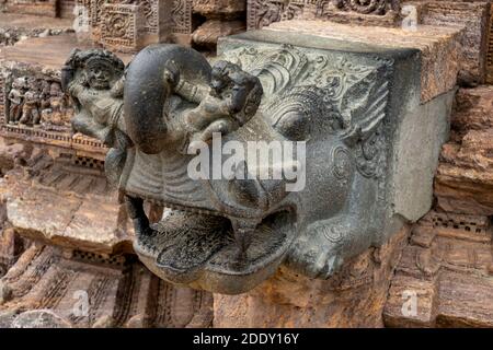 Konark, 9. April 2014, Nahaufnahme von schwarzem Granitstein Gargoyle mit Menschen und Tierfiguren auf Hindu Sun Temple, UNESCO Heritage Site, Odisha, Indien Stockfoto