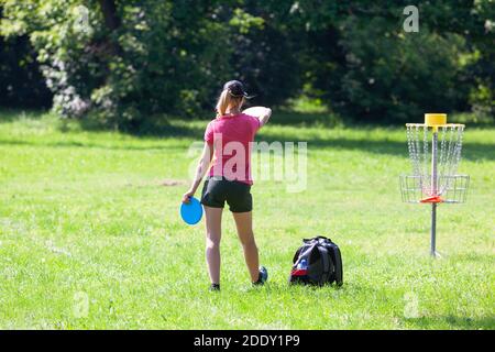 Junge Frau spielt fliegende Scheibe Sport-Spiel im Park Stockfoto