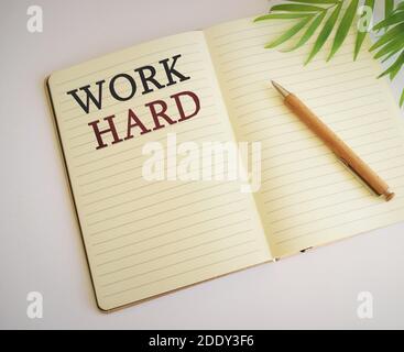 Word schreiben Text harte Arbeit. Geschäftskonzept, um immer viel Aufwand und Sorgfalt in Arbeit oder Ausdauer zu stecken. ARBEITEN SIE HARTEN Text in Notizbuch geschrieben Stockfoto