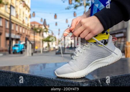 Weibliche Fitness-Läuferin, die Sportschuhschnüren bindet. Nahaufnahme von Händen und Beinen. Stockfoto