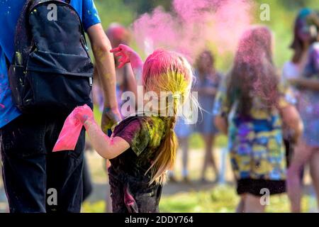 Ein kleines Mädchen wirft trockene Farbe auf dem Holi Festival. Stockfoto