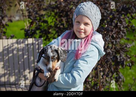 Mädchen Kind spielt mit Dackel Hund im Herbst sonnigen Park Stockfoto