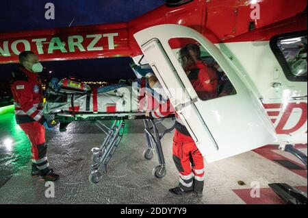 20. November 2020, Baden-Württemberg, Tübingen: Patrick Bierherr, Notarzt (l) und Nick Ehling, Pilot, schiebt einen verletzten Patienten aus einem Intensivhubschrauber Christoph 111 von der DRF Stiftung Luftrettung gemeinnützige AG auf dem Hubschrauberlandeplatz der BG Klinik Tübingen. Foto: Marijan Murat/dpa Stockfoto