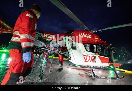 20. November 2020, Baden-Württemberg, Tübingen: Patrick Bierherr, Notarzt (l) und Nick Ehling, Pilot, schiebt einen verletzten Patienten aus einem Intensivhubschrauber Christoph 111 von der DRF Stiftung Luftrettung gemeinnützige AG auf dem Hubschrauberlandeplatz der BG Klinik Tübingen. Foto: Marijan Murat/dpa Stockfoto