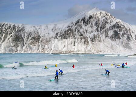 Junge Männer surfen unter arktischen Bedingungen am Flakstag Beach, Lofoten, Norwegen, Europa Stockfoto