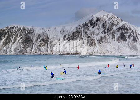 Junge Männer surfen unter arktischen Bedingungen am Flakstag Beach, Lofoten, Norwegen, Europa Stockfoto