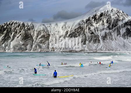 Junge Männer surfen unter arktischen Bedingungen am Flakstag Beach, Lofoten, Norwegen, Europa Stockfoto