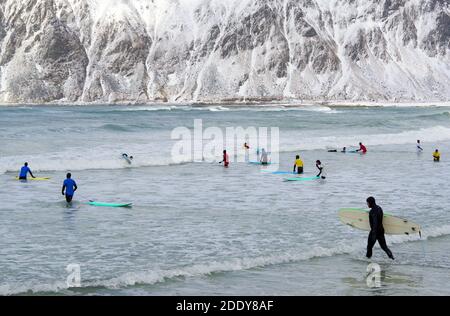 Junge Männer surfen unter arktischen Bedingungen am Flakstag Beach, Lofoten, Norwegen, Europa Stockfoto