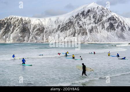 Junge Männer surfen unter arktischen Bedingungen am Flakstag Beach, Lofoten, Norwegen, Europa Stockfoto