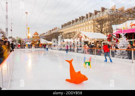 Eislaufbahn. Weihnachtsmarkt, Paris (tuilerien), Frankreich. Schöne Tagesaufnahme von Familien, die im Winter Spaß auf dem Eis haben. Stockfoto