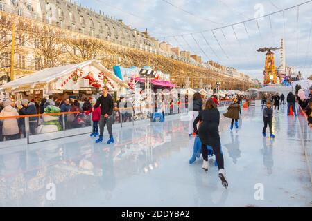 Eislaufbahn. Weihnachtsmarkt, Paris (tuilerien), Frankreich. Schöne Tagesaufnahme von Familien, die im Winter Spaß auf dem Eis haben Stockfoto