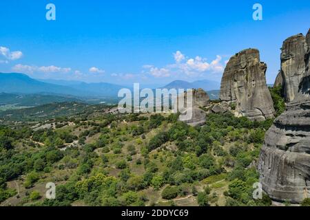 Meteora Land im Himmel: Große alte Stadt von Meteora in Griechenland. Bäume, alte Häuser, blauer Himmel und weiße Wolken. Stockfoto