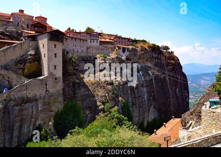 Meteora Land im Himmel: Große alte Stadt von Meteora in Griechenland. Bäume, alte Häuser, blauer Himmel und weiße Wolken. Stockfoto