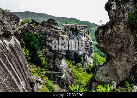 Meteora Land im Himmel: Große alte Stadt von Meteora in Griechenland. Bäume, alte Häuser, blauer Himmel und weiße Wolken. Stockfoto