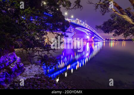 Die Auckland Harbour Bridge, Auckland, Neuseeland, wunderschön beleuchtet in der Nacht. Vom Stokes Point am nördlichen Ende gesehen Stockfoto