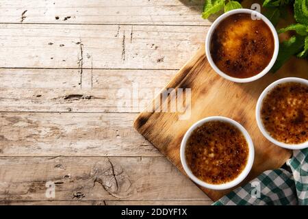 Hausgemachte Creme Brulee in Schüssel auf Holztisch Stockfoto