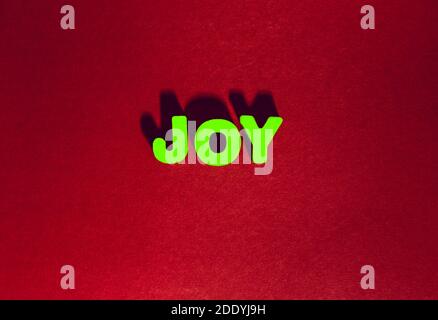 Holz bemalte grüne Buchstaben mit Worttext Schreibfreude auf Handwerk roten Papier Hintergrund mit Schatten und Volumen, genießen und Glück Stockfoto