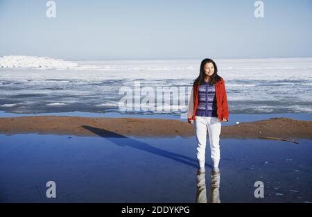 Junge erwachsene Frau draussen eisige Landschaft genießen. Stockfoto