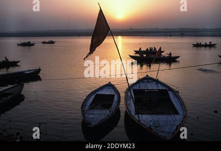 24.03.2010, Varanasi, Uttar Pradesh, Indien, Asien - Tagesanbruch mit Sonnenaufgang über hölzernen Ruderbooten an einem Ghat am Ufer entlang des heiligen Ganges Flusses. Stockfoto