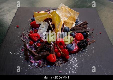 Nahaufnahme der umgedrehten millefeuille mit Ricotta und Mascarpone Sahne, Bitterschokolade Flocken und Waldbeeren Stockfoto