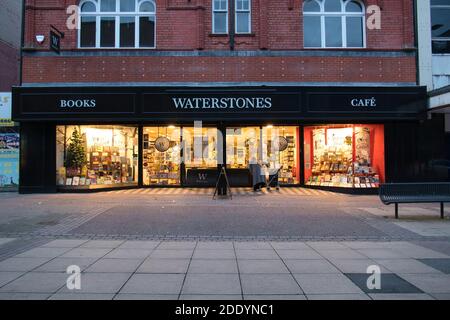 Eine einzelne ältere Person liest ein Schild vor einer geschlossenen Niederlassung des britischen Buchhändlers Waterstones auf einer sinkenden Hauptstraße im Nordwesten Großbritanniens. Stockfoto