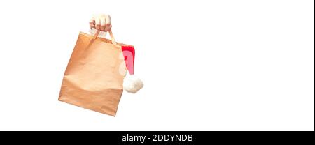 Hand hält Basteltasche mit weihnachtsmann Hut auf weißem Hintergrund isolieren, Banner, Kopierraum Stockfoto