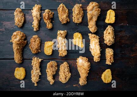 Hausgemachte knusprig gebratene Hühnerteile auf alten dunklen Holztisch, flach legen. Stockfoto