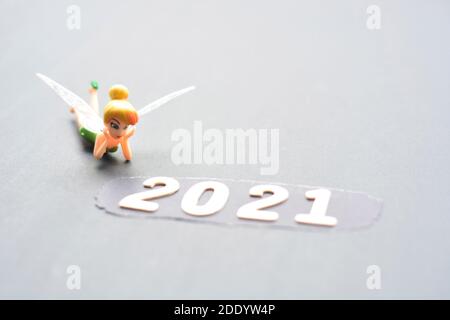 Neues Jahr 2021 Konzept Mit Verschwommener Miniatur Fee Starrt Auf Zahlen. Dunkler Hintergrund. Konzept Für Das Neue Jahr 2021 Stockfoto