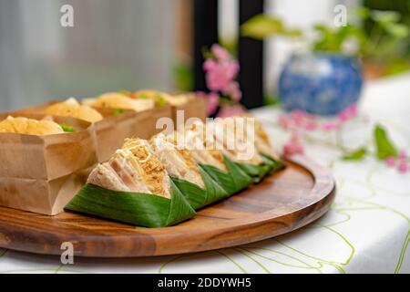 Nahaufnahme von getrockneten Schweinebandwiches, die mit verschwommenem Hamburger dahinter angeordnet sind. Stockfoto