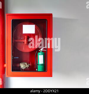 Die Schränke der Brandschutzanlage sind mit dem Notfall geregelt Feuerlöscher und Walzrohr Stockfoto
