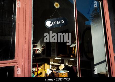 "Geschlossen" Schild an der Glastür eines alten Geschäfts in einer ruhigen Straße in der Altstadt. Stockfoto