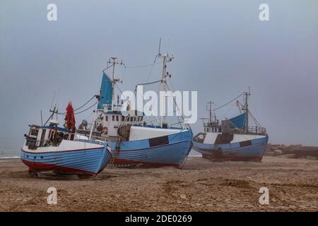 Fischkutter am Strand an der Westküste von Dänemark an einem nebligen Tag Stockfoto